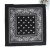 Black fabric with white paisley embroidery featuring a central square pattern and ornate borders.