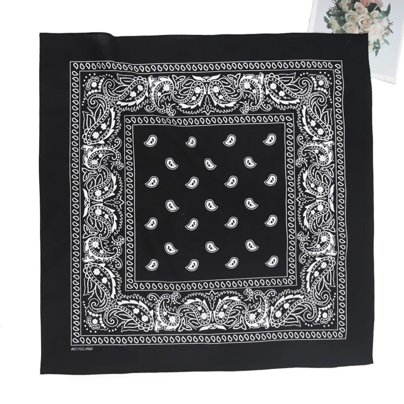 Black fabric with white paisley embroidery featuring a central square pattern and ornate borders.