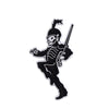 Une épingle émaillée noire représentant une figure squelettique jouant du violon.
