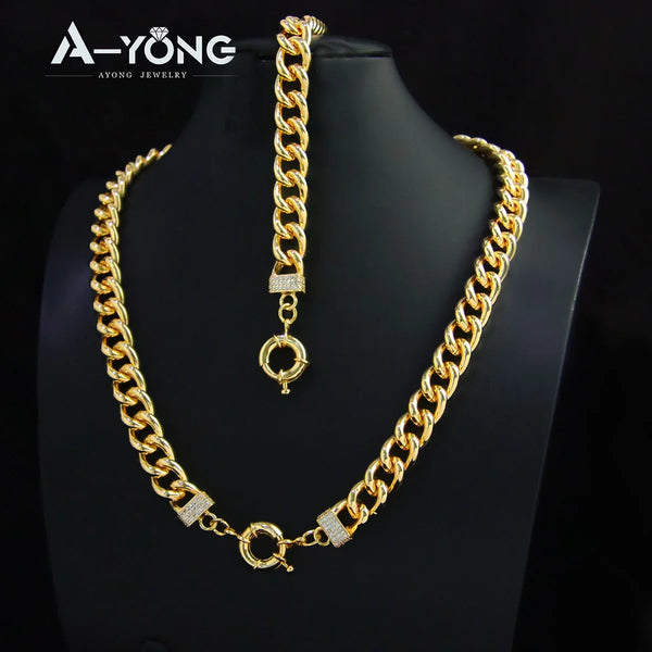A gold plated Cuban chain necklace with a pendant and a box design detail displayed on a black mannequin.