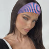 Gros plan d'un mannequin portant un bandeau pour cheveux rayé sur son front.