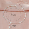 A delicate sparkling zircon heart cross anklet is displayed on a pink fabric with size measurements.