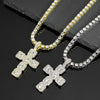 A close-up of a sparkling rhinestone cross pendant necklace displayed on a dark surface.