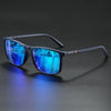 A pair of dark-framed sunglasses with blue mirrored lenses resting on a dark surface.