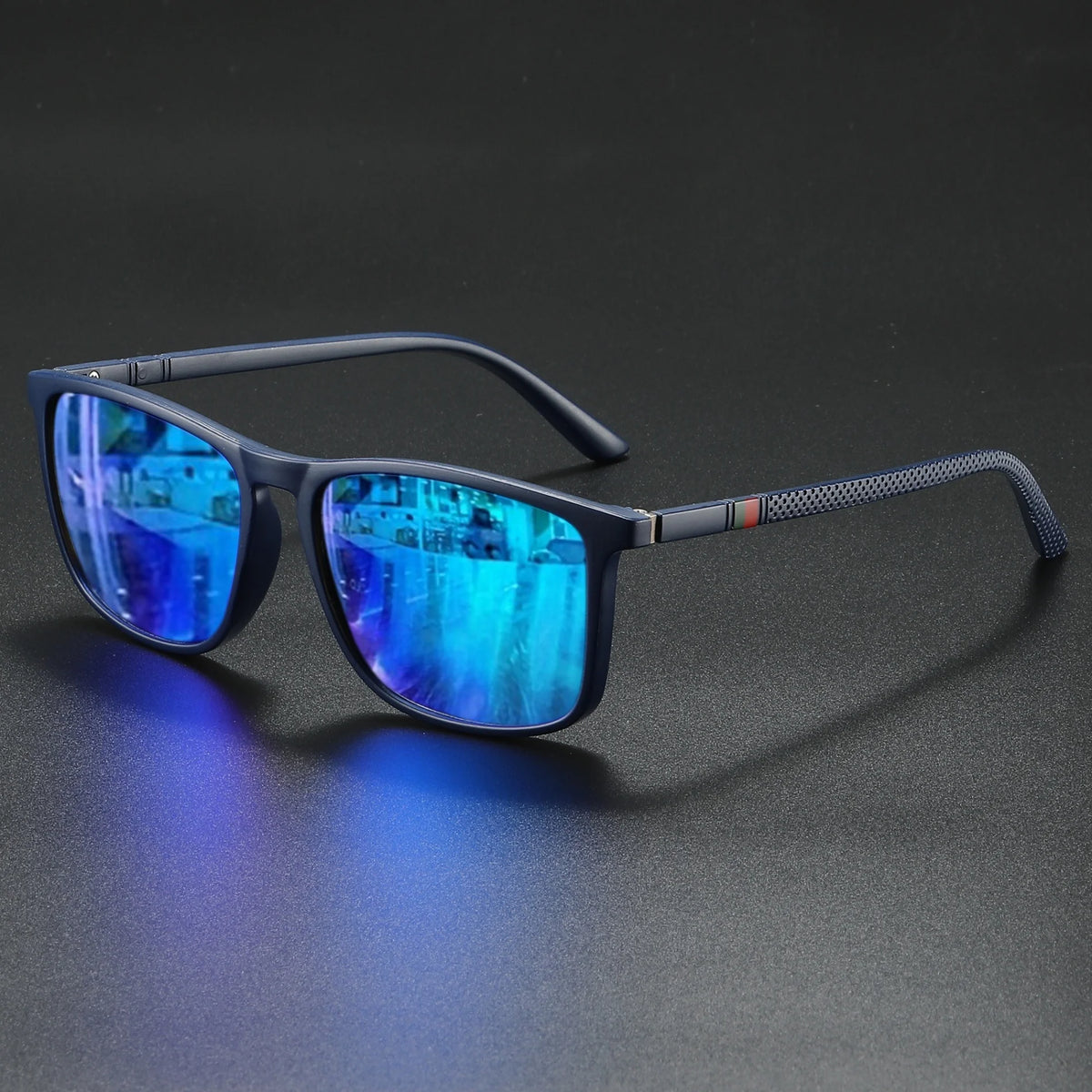 A pair of dark-framed sunglasses with blue mirrored lenses resting on a dark surface.