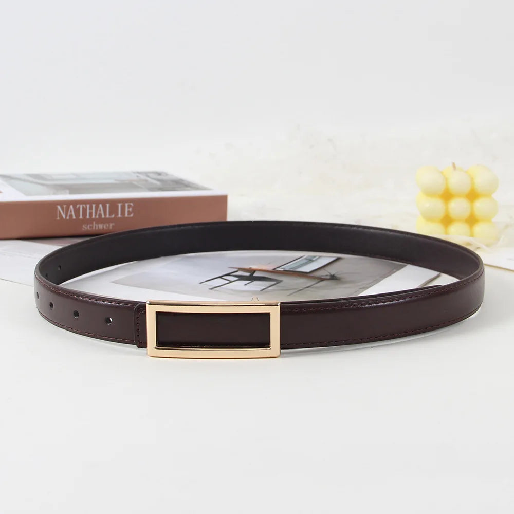 A dark brown faux leather belt with a gold rectangular buckle is displayed on a white surface.