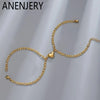 Gold stainless steel heart magnetic bracelet set for couples displayed on a gray background