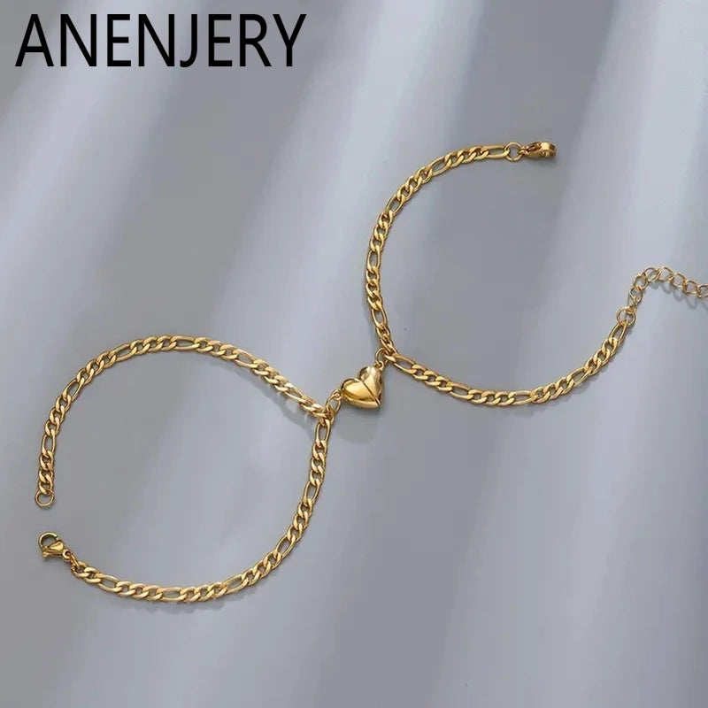 Gold stainless steel heart magnetic bracelet set for couples displayed on a gray background