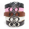 A stack of vintage gothic moon star buckle belts in black, pink, brown, and silver finishes.