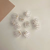 A set of clear acrylic adjustable hair claw clips arranged on a white surface.