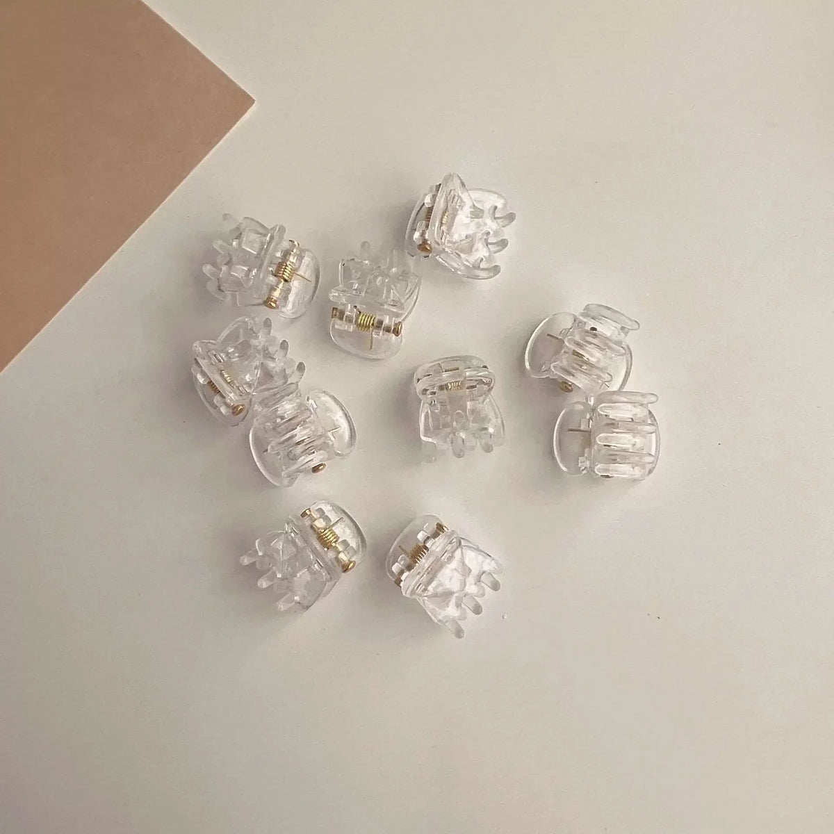 A set of clear acrylic adjustable hair claw clips arranged on a white surface.
