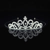 Tiara y corona de princesa de cristal brillante para el cabello, exhibida en una superficie reflectante.