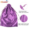 Purple satin wig storage bag with a drawstring design and a pink fabric swatch.