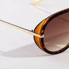 Primer plano de gafas de piloto vintage grandes con lentes tintados en ámbar y monturas de metal dorado.