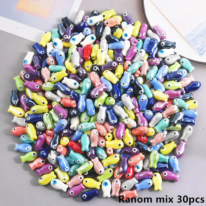 A pile of colorful ceramic fish charms used for DIY jewelry making