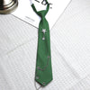A dark green tie with a silver star pendant and chain, displayed on a white shirt.