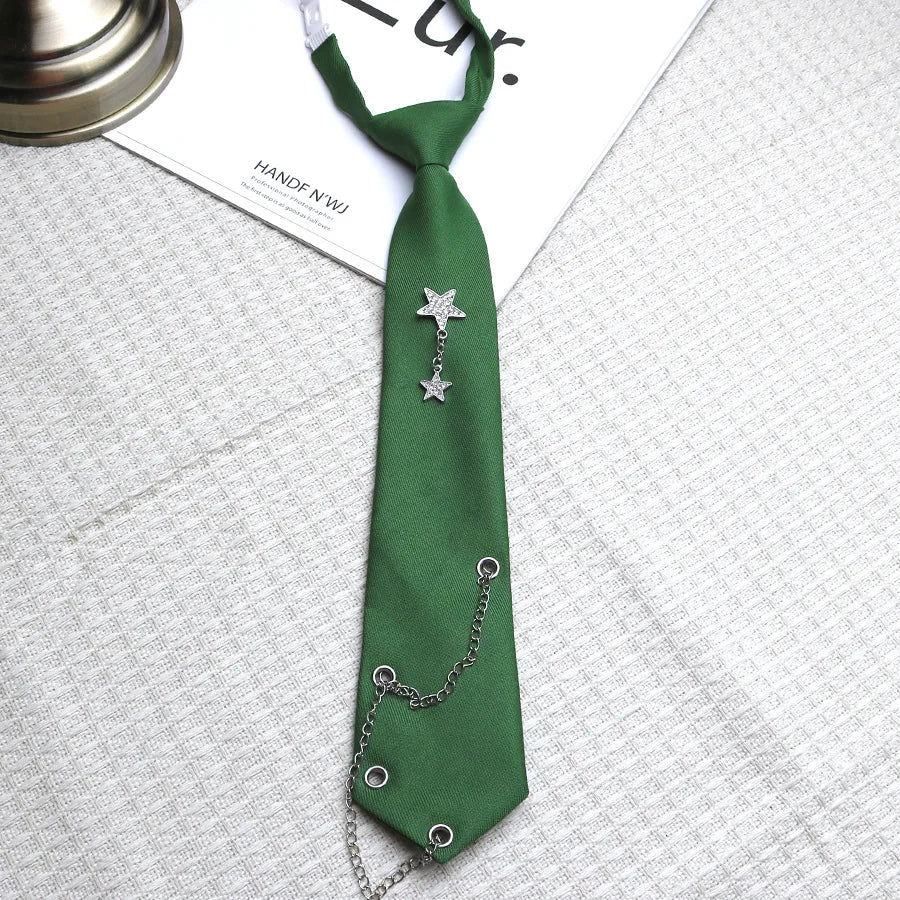 A dark green tie with a silver star pendant and chain, displayed on a white shirt.