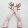 Pink satin fingerless gloves worn by a person, showing the hands and arms.