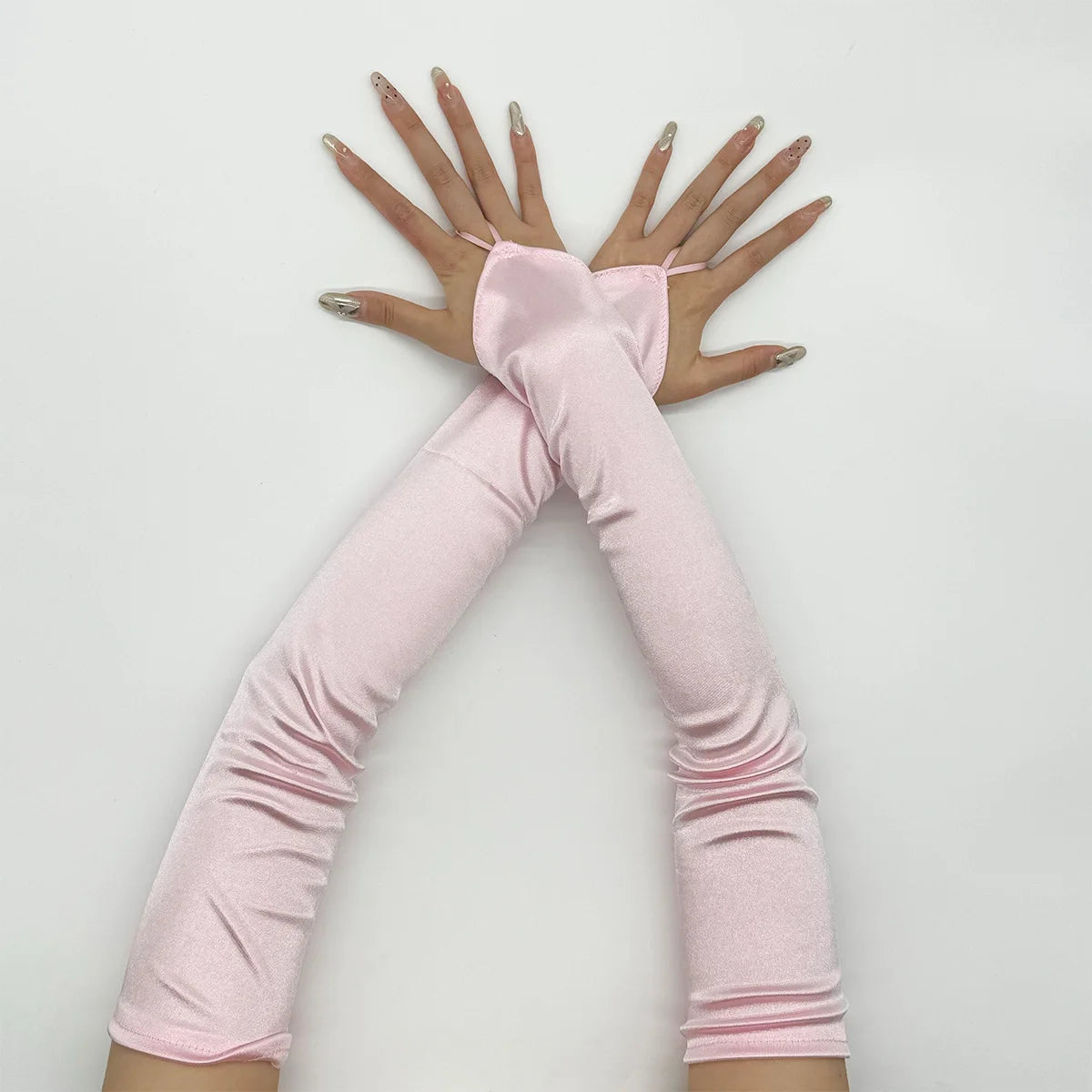 Pink satin fingerless gloves worn by a person, showing the hands and arms.