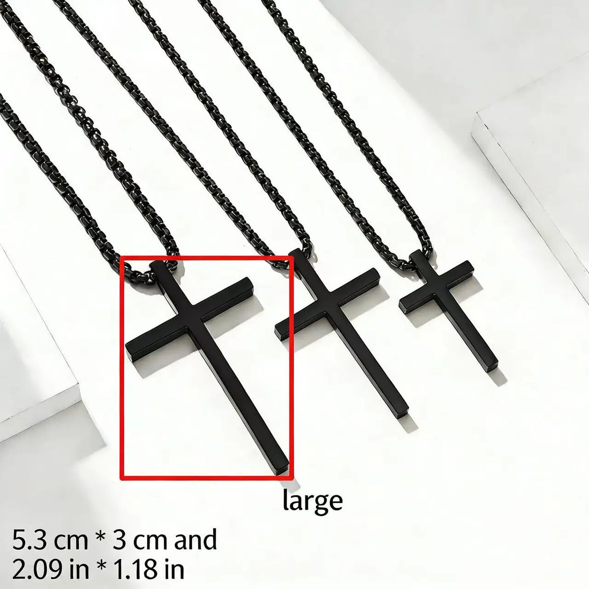 A set of black stainless steel cross pendant necklaces displayed on a white surface.