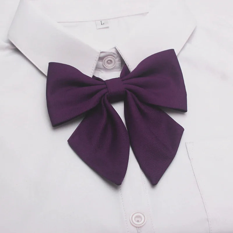 A purple butterfly ribbon tie set worn as a bow on a white collared shirt.