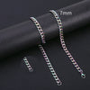 A close-up of a silver-toned Cuban link necklace with a 7mm chain, displayed on a dark surface.