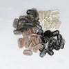 A collection of precision hair extension clips in various shades of brown, black, and beige.