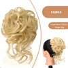 Ein Bund blondes, gewelltes synthetisches Haar neben einer fertigen Duttfrisur.