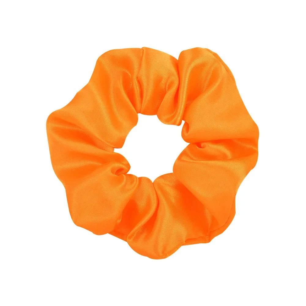 A bright orange satin scrunchie tied in a bow shape.
