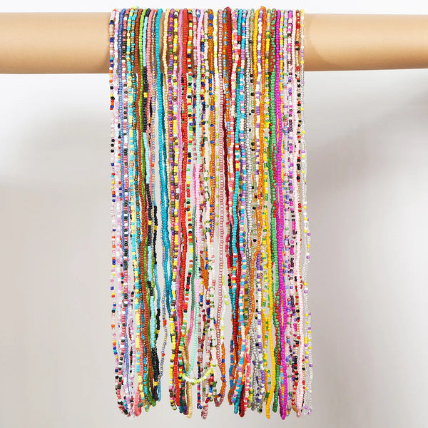A long, colorful beaded body chain draped over a wooden rod.
