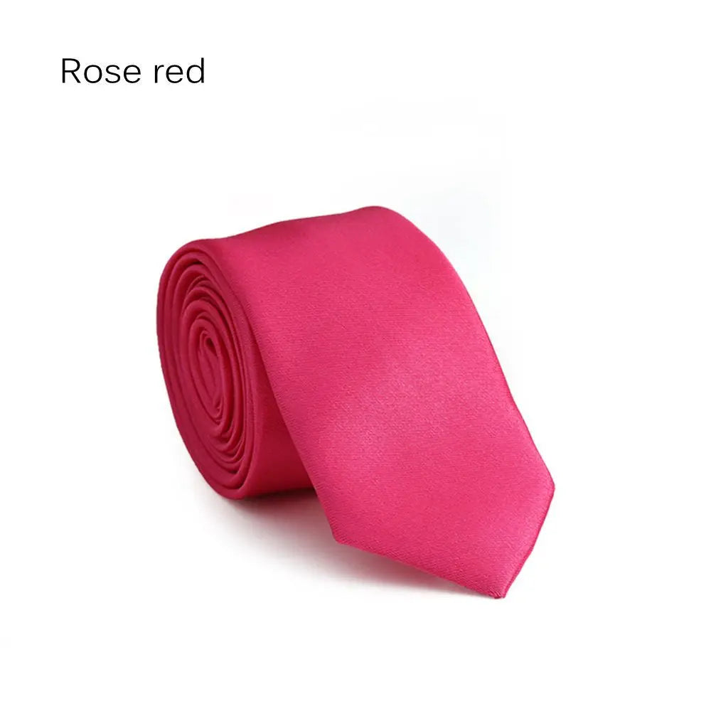 Ein roter Seiden-Krawatten, gerollt und vor weißem Hintergrund präsentiert.