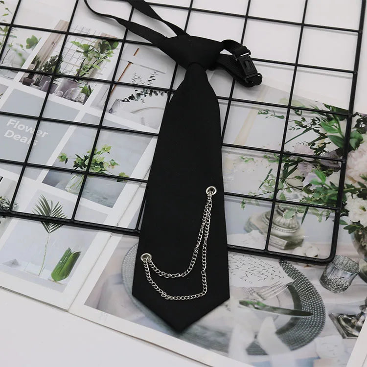 A black classic chain necktie accessory with a silver chain, displayed against a grid background.