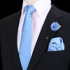Chaqueta de traje azul marino con camisa blanca, corbata de seda azul claro y un prendido y pañuelo de bolsillo florales a ju