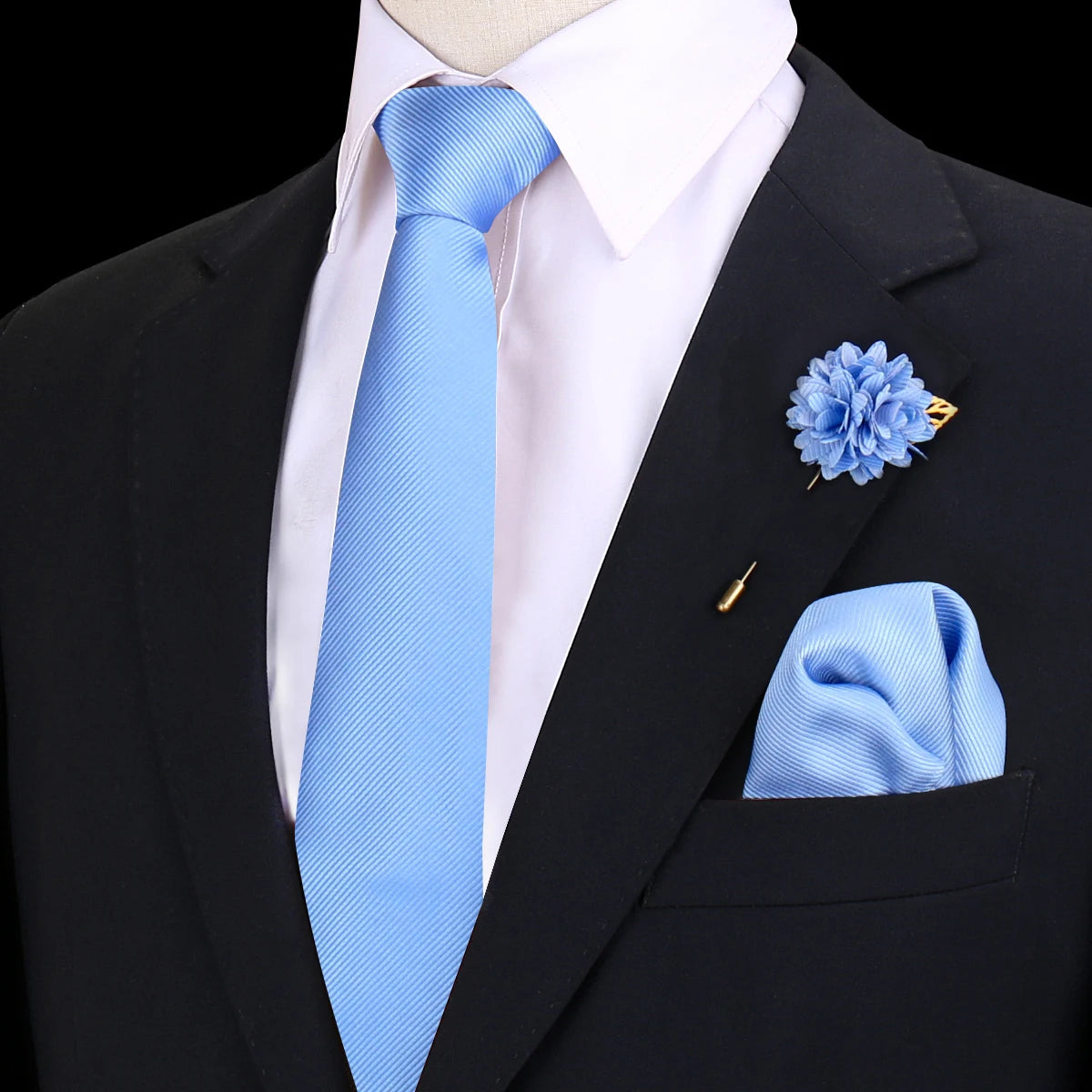 Chaqueta de traje azul marino con camisa blanca, corbata de seda azul claro y un prendido y pañuelo de bolsillo florales a ju