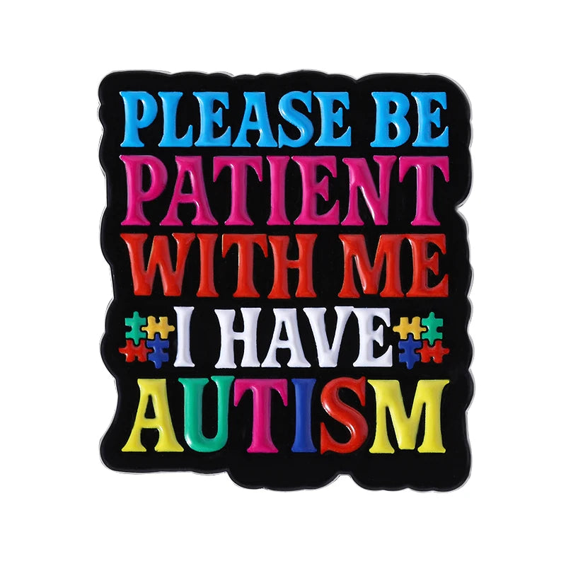 Black enamel pin with colorful text that reads Please be patient with me I have autism