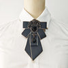 A black handcrafted tie with diamond embellishments worn on a white collared shirt.