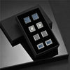 A black presentation box displaying six silver and blue patterned cufflinks.