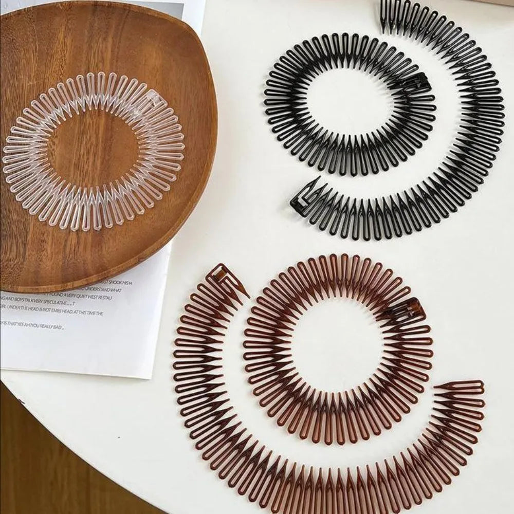 Un jeu de deux pinces à cheveux en plastique et élastiques, marron et noir, sont présentés sur une surface blanche.
