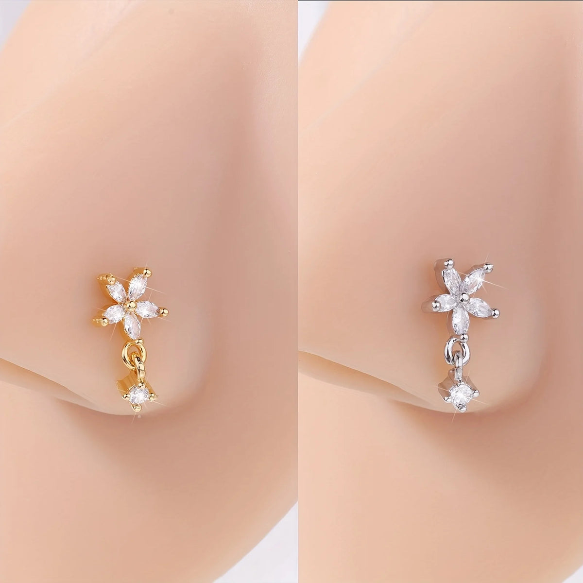 Un paire de anneaux à l'oreille en acier inoxydable en forme de L avec des charms floraux, montrés sur un teint de peau.