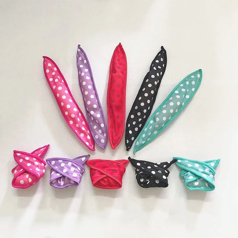 A set of ten flexible hair curling rollers in various shades of pink, purple, and green.