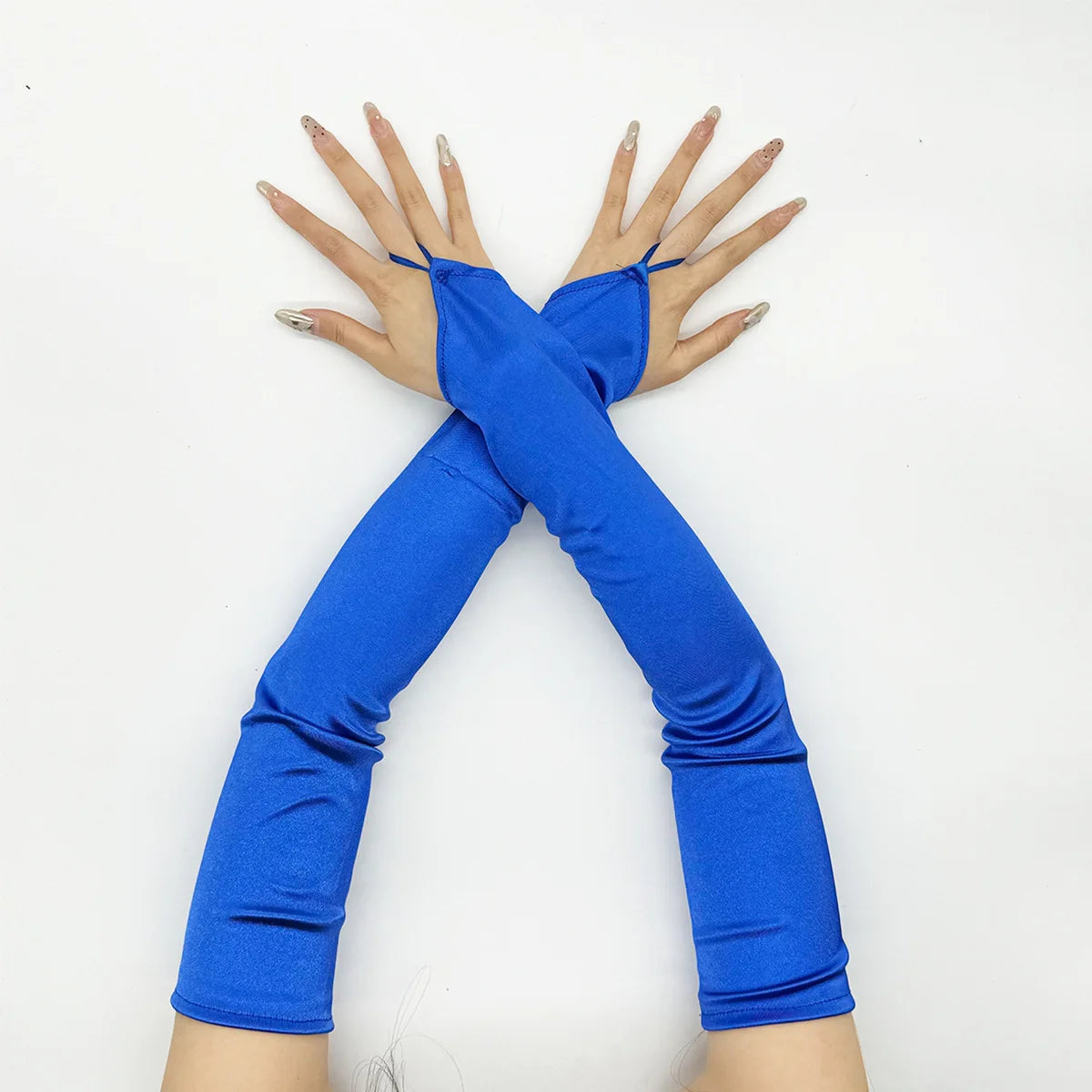 A person wearing bright blue satin fingerless gloves with long sleeves, posing with their arms outstretched.