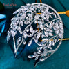 A delicate bridal hair hoop adorned with sparkling clear rhinestones and leaves on a dark teal background.