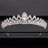 A sparkling crystal bridal crown with a prominent central stone displayed on a dark surface.