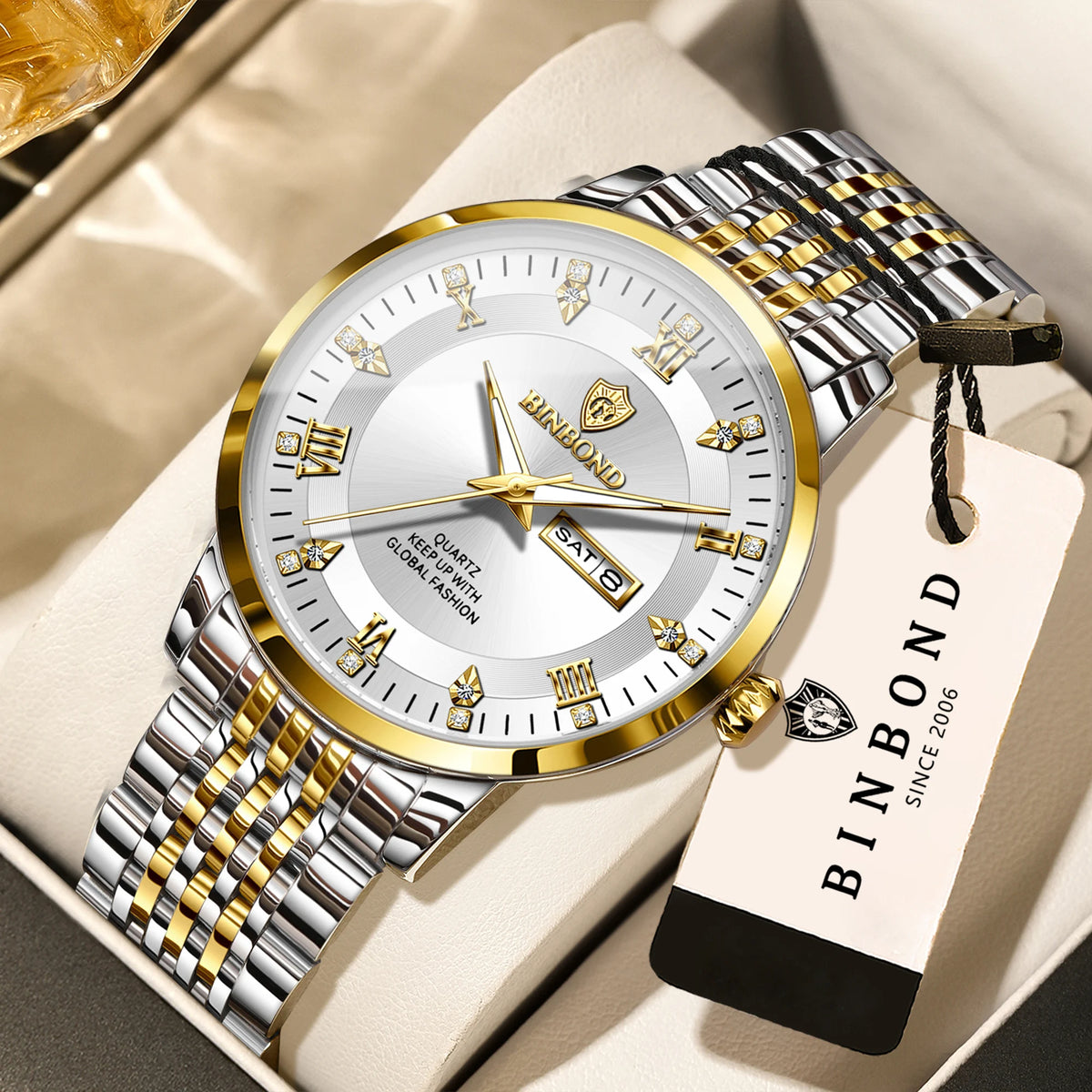 A gold and silver wind-up watch with a leather strap is displayed on a light background.