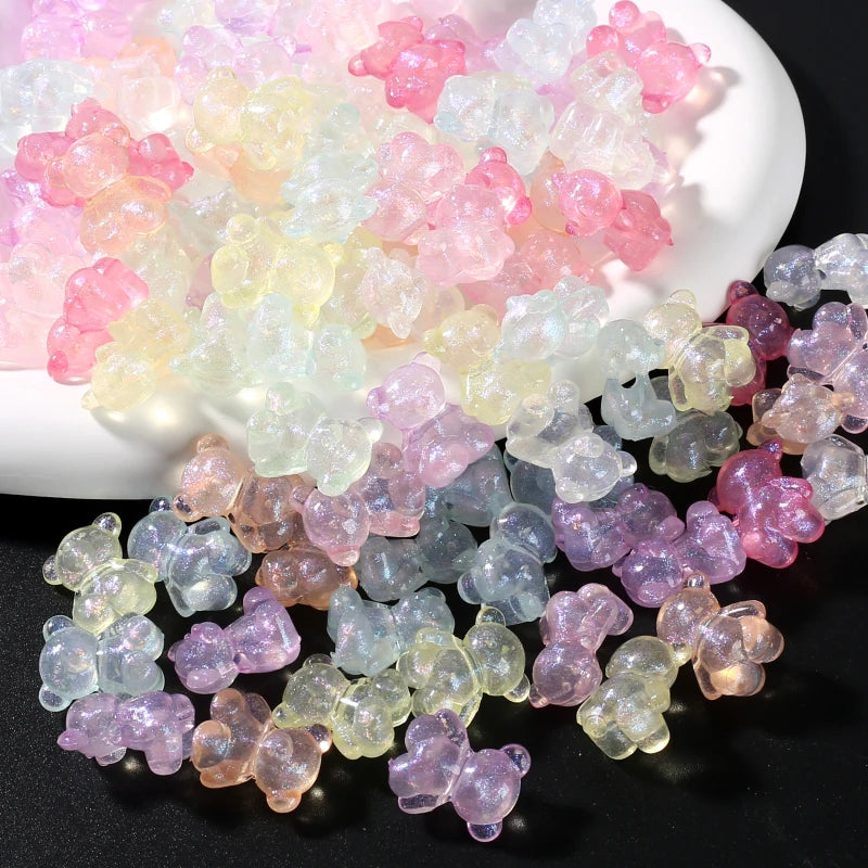A pile of luminous glow-in-the-dark acrylic beads in various shades of pink, yellow, and purple.