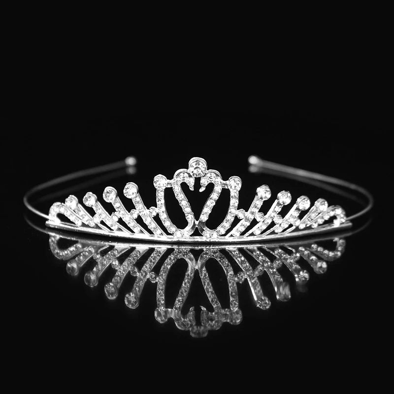 Tiara y corona de princesa de cristal brillante como accesorio para el cabello, exhibida contra un fondo negro.