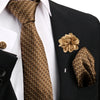 Nahaufnahme eines eleganten Herren-Krawattensets mit goldener Krawatte, Blume und Einstecktuch auf schwarzem Hintergrund