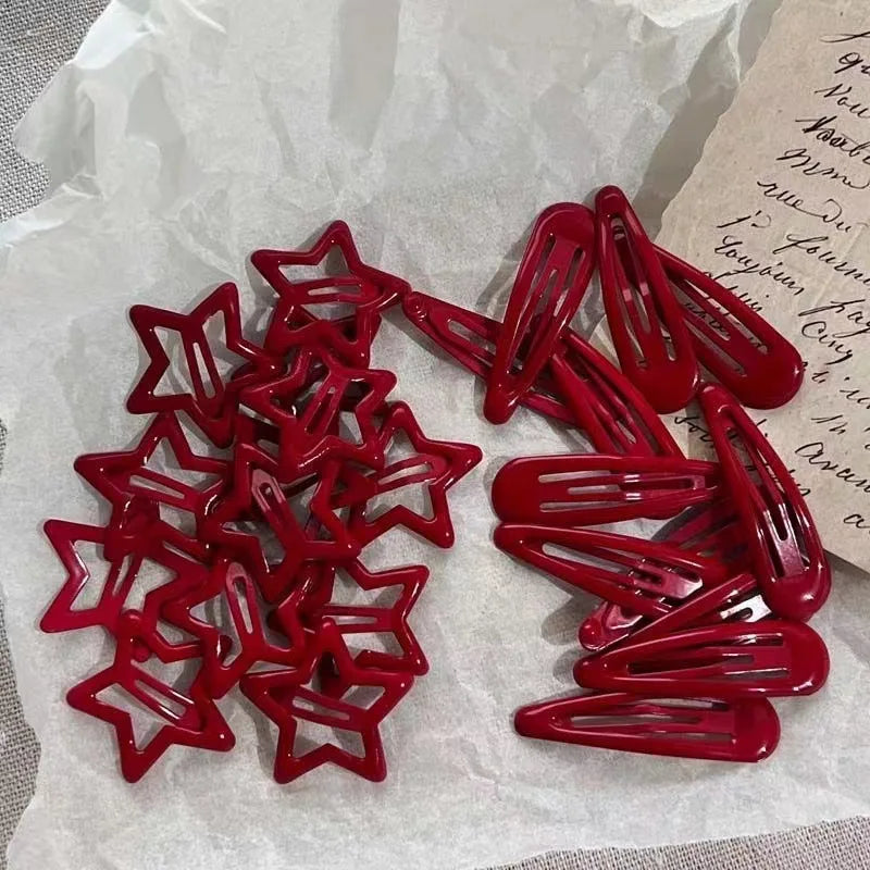 A set of red star snap clips for hair and barrettes displayed on white paper.
