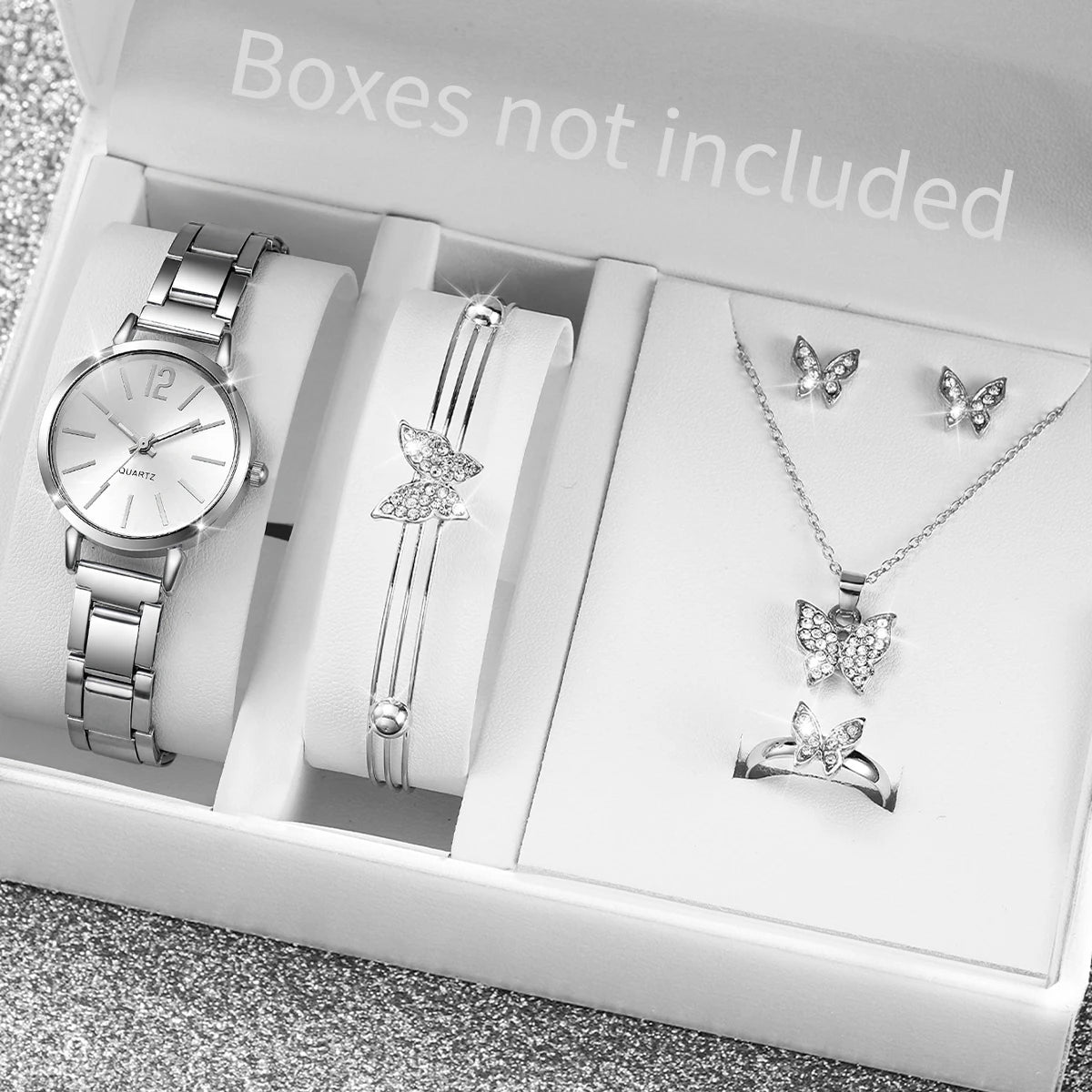 A white box displays an elegant quartz wrist watch, a silver bracelet, a necklace with butterfly pendants, and a silver ring.