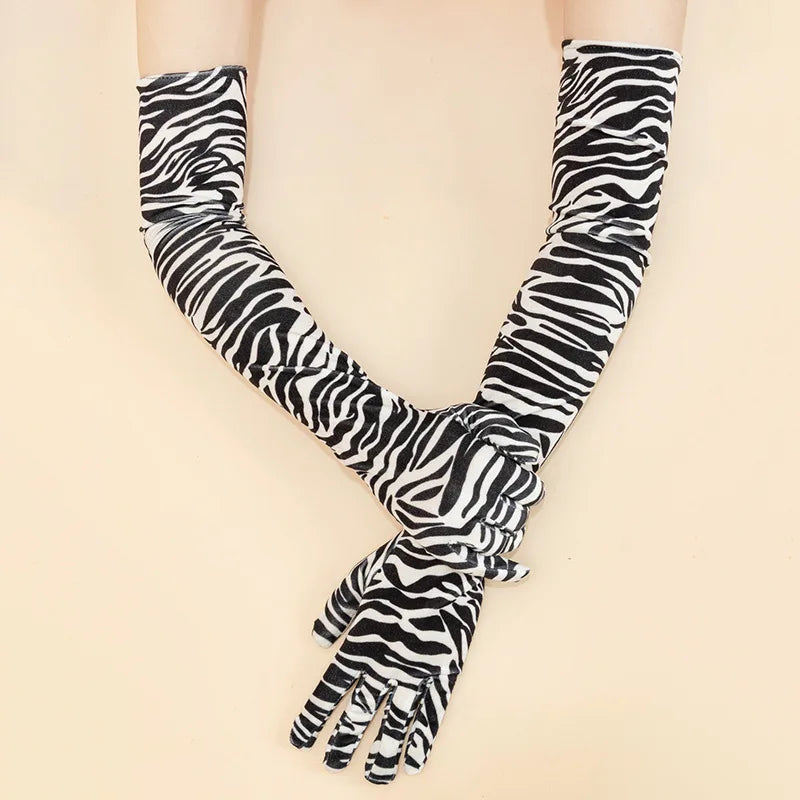 Lange Performancehandschuhe mit schwarz-weißem Zebra-Print am Arm getragen.